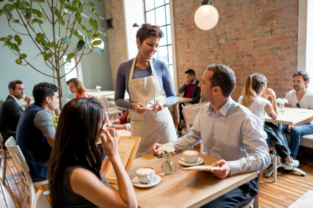 Efficient service in action: A waitress gracefully takes orders amidst the bustling ambiance of a busy restaurant.